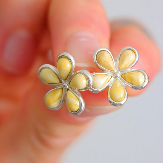 amber stud earrings flower shape blurred background