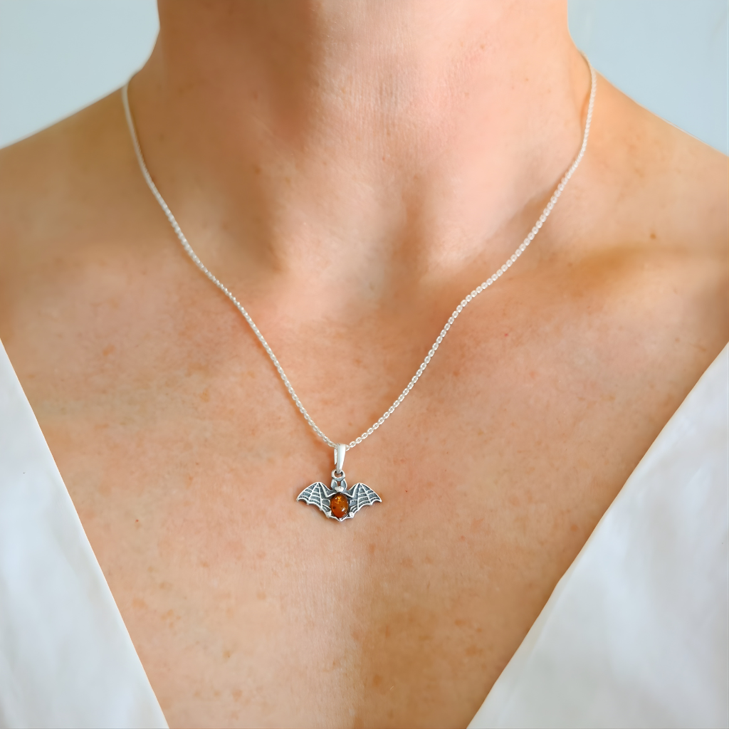 amber necklace with a pendant featuring an orange gemstone on a plain background