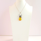 s925 necklace-Baltic lemon amber black widow pendant necklace in sterling silver on display.