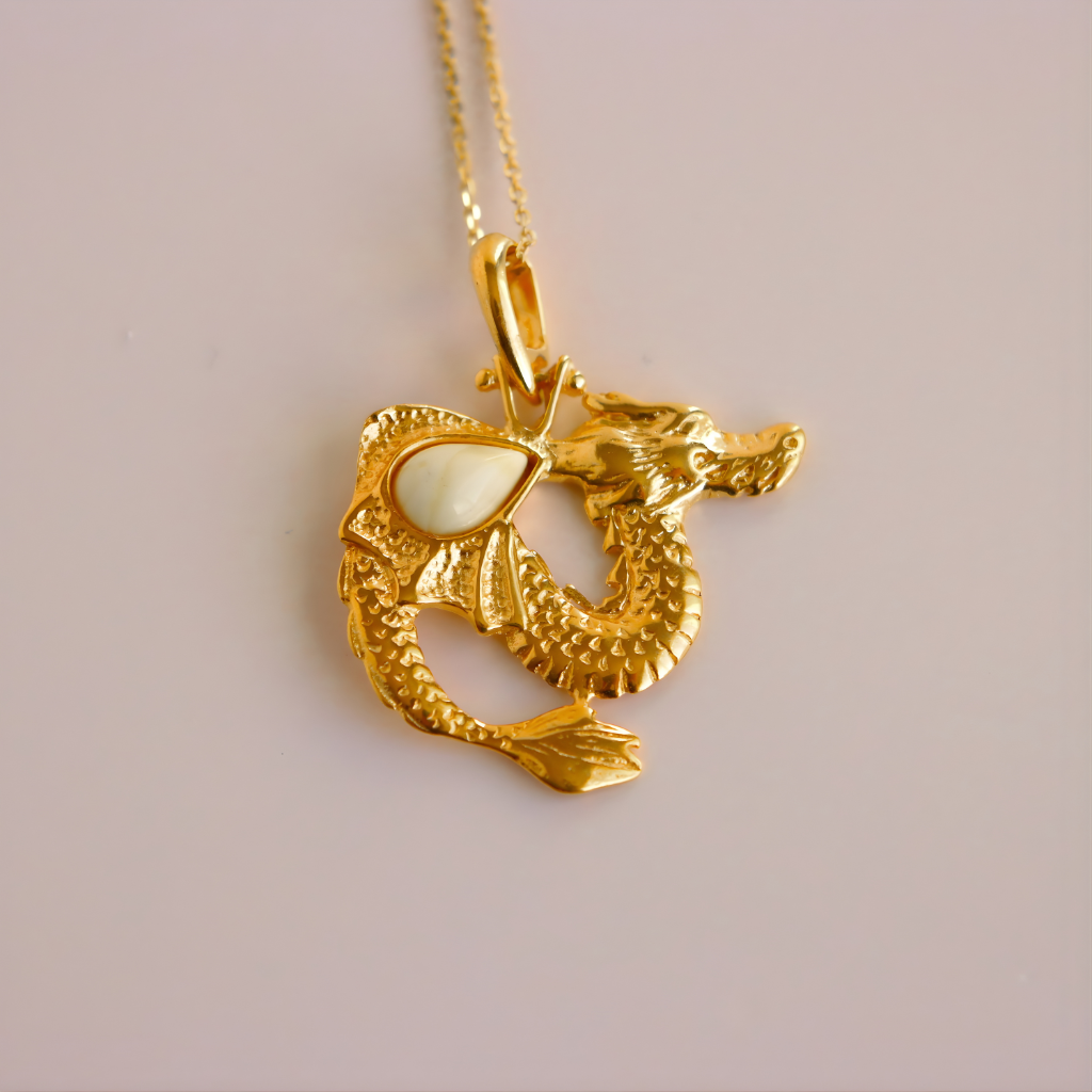 Gold dragon pendant with a white stone on a light gray background