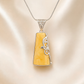 butterscotch amber necklace with silver floral design on a beige background
