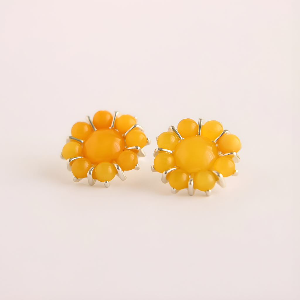 Pair of yellow flower earrings on a light beige background