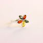 Multicolored gemstone amber ring on a light pink background