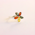 Multicolored gemstone amber ring on a light pink background