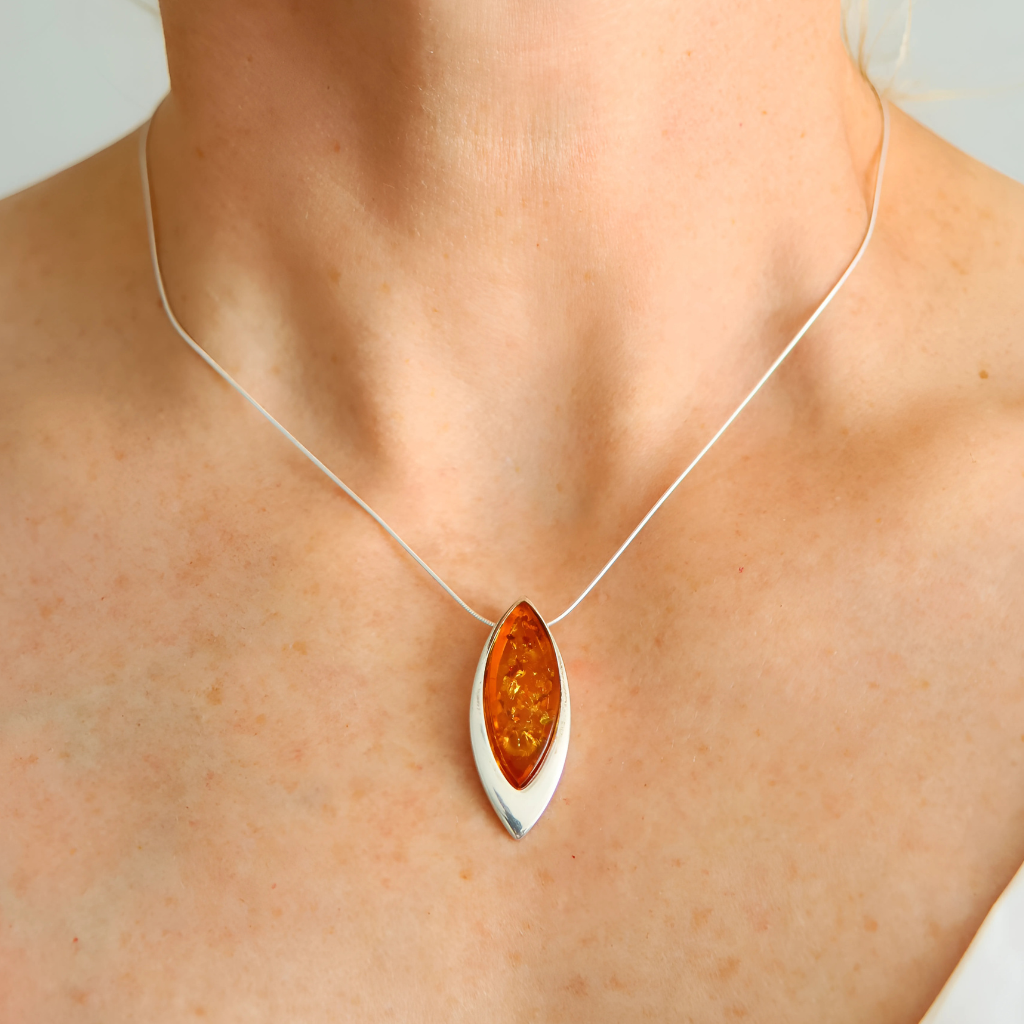 sterling silver necklace with a amber pendant on a person's neck