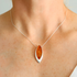 sterling silver necklace with a amber pendant on a person&