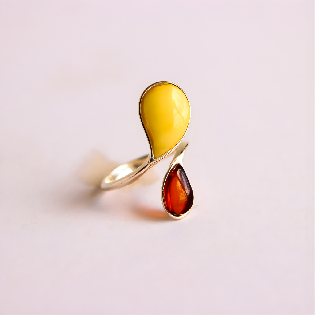 sterling silver ring with yellow and red teardrop-shaped gemstones on a light pink background