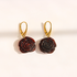 A pair of amber rose earrings drop earrings with dark reddish-brown carved petals and gold leverback hooks, displayed on a clean white background.