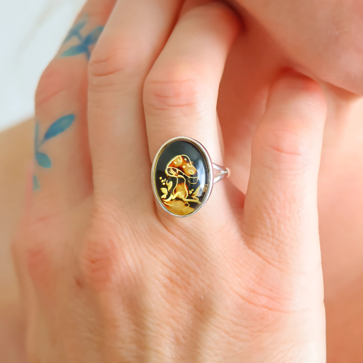 Close-up of a hand wearing a gold and black mushroom ring 