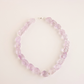 Amethyst beaded choker necklace on a light pink background