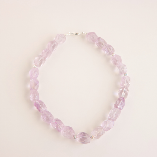 Amethyst beaded choker necklace on a light pink background