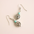 Silver western earrings with turquoise beads on a beige background