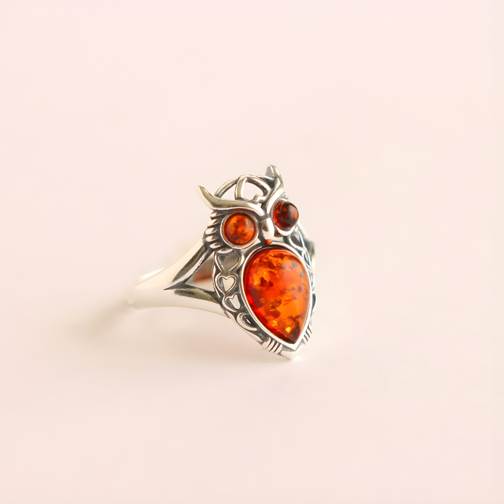 Silver amber ring with amber stones on a beige background
