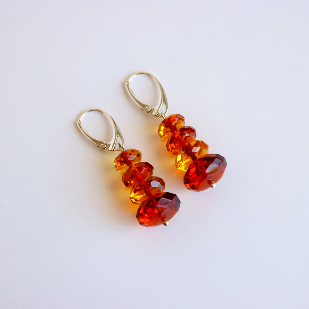 amber drop earrings with red and orange gemstones on white background