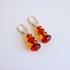 amber drop earrings with red and orange gemstones on white background