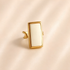 White amber ring with rectangular amber stone set in polished gold-tone metal.