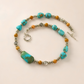 western turquoise Necklace with turquoise and orange beads on a beige background