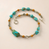 western turquoise Necklace with turquoise and orange beads on a beige background
