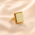 Gold amber ring with a square stone on a beige background