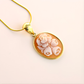 Gold flower necklace on a light pink background