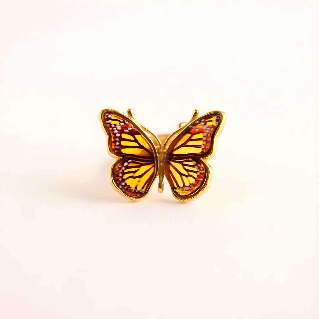 Butterfly Ring with gold frame and orange wings on a white background