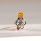 An ornate sterling silver amber octopus ring featuring a large round amber top stone and three smaller amber accent stones, photographed on a clean, light beige background.