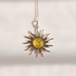 A silver lemon Baltic amber sun pendant necklace featuring a central round yellow amber inlay, suspended from a delicate silver chain against a warm off-white background.