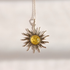 A silver lemon Baltic amber sun pendant necklace featuring a central round yellow amber inlay, suspended from a delicate silver chain against a warm off-white background.