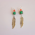 feather drop earrings with green and orange gemstone on gray background
