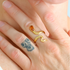 Gold snake ring on a finger with a tattoo of a bear.