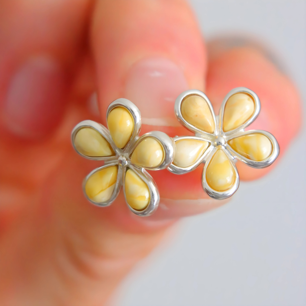 amber stud earrings flower shape blurred background