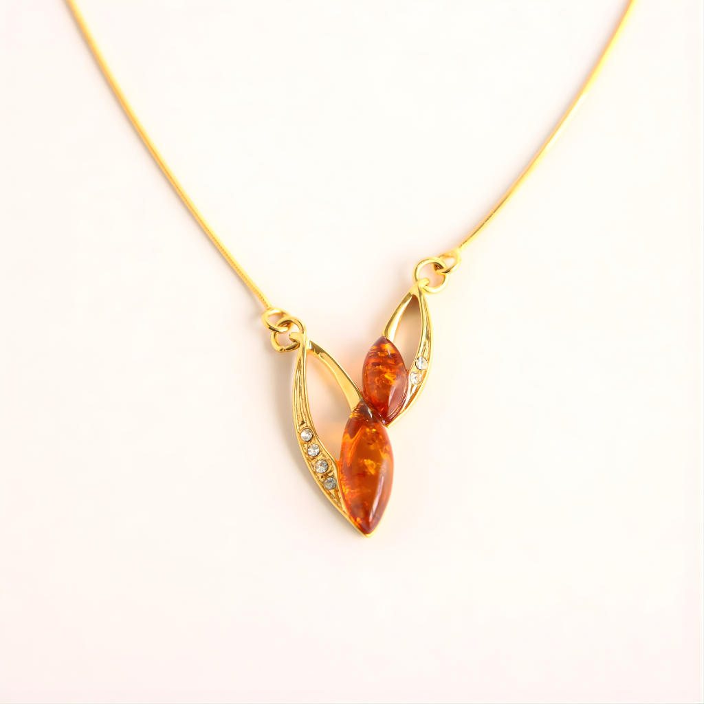 Gold amber necklace with a pendant featuring amber-colored stones on a white background