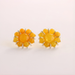 Yellow flower earrings on a light beige background
