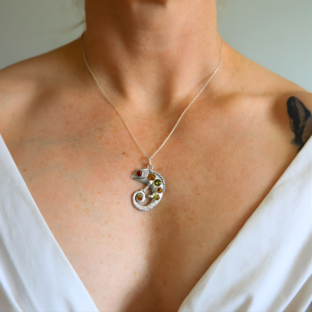  Necklace with a Chameleon amber pendant featuring multiple gemstones worn by a person in a white top.