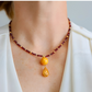 Close-up of Baltic butterscotch amber and garnet with gold-filled pendant