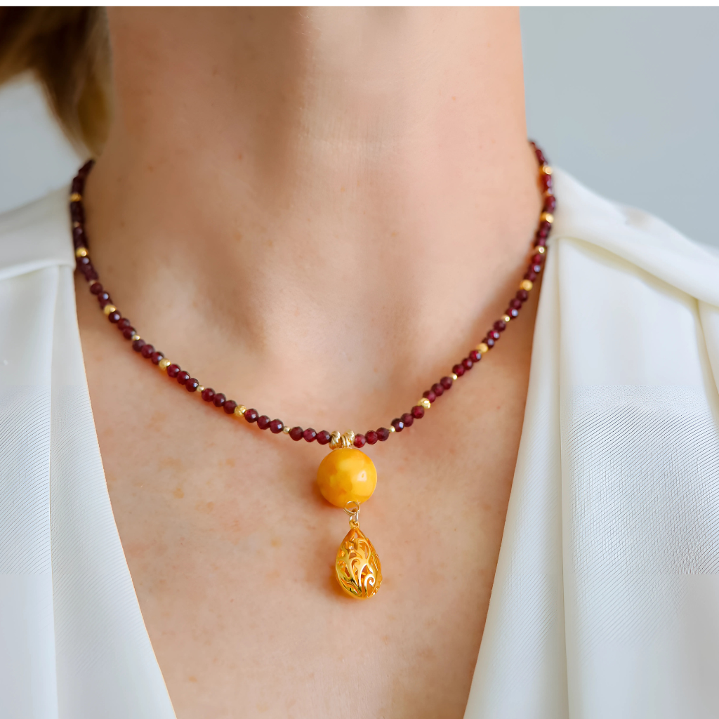 Close-up of Baltic butterscotch amber and garnet with gold-filled pendant