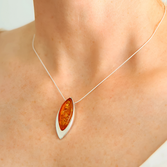sterling silver necklace with a pendant featuring amber stone worn by a person