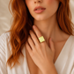 Woman wearing a gold amber ring on her finger, close-up of face and hand