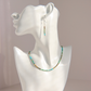 A matching Hubei turquoise beaded necklace and drop earring set displayed on a white mannequin bust. The jewelry features small, round beads in turquoise, green, brown, and white, suspended on silver-toned wire hooks.