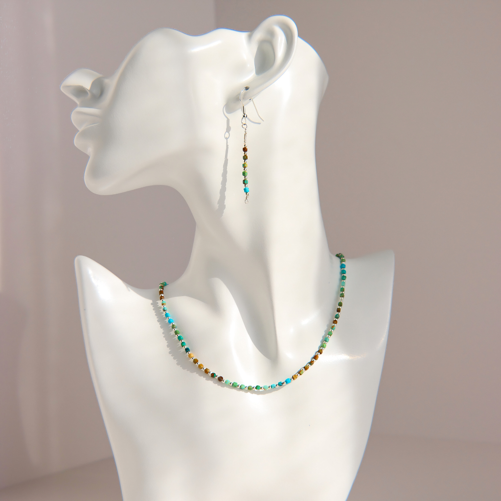 A matching Hubei turquoise beaded necklace and drop earring set displayed on a white mannequin bust. The jewelry features small, round beads in turquoise, green, brown, and white, suspended on silver-toned wire hooks.