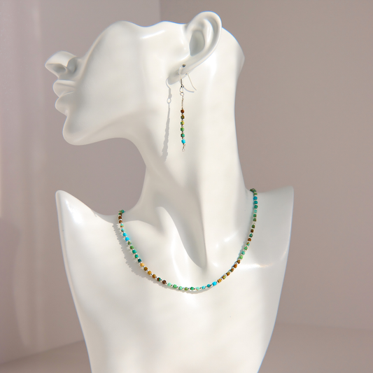 A matching Hubei turquoise beaded necklace and drop earring set displayed on a white mannequin bust. The jewelry features small, round beads in turquoise, green, brown, and white, suspended on silver-toned wire hooks.