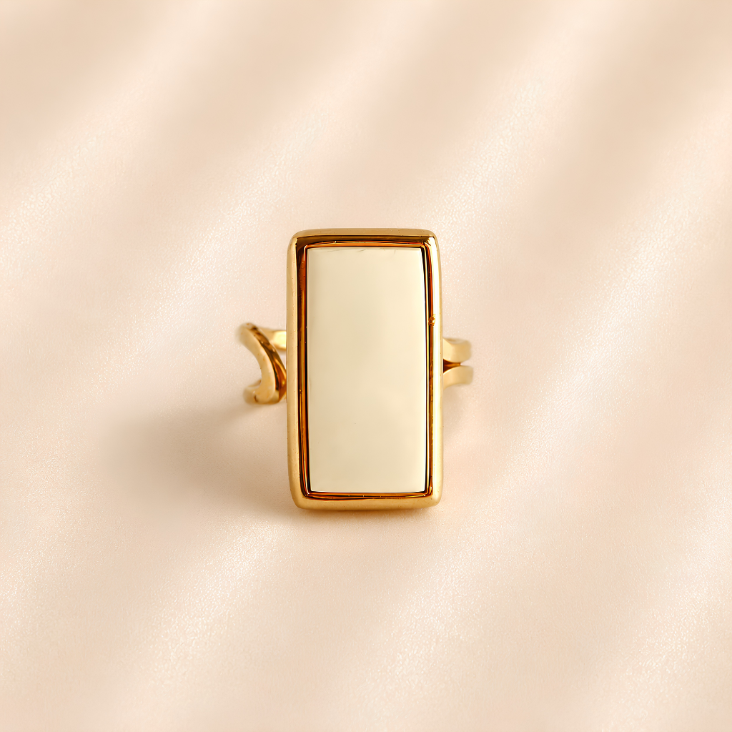 Front view of white amber ring with rectangular stone and gold-tone frame.