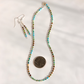 A Hubei turquoise beaded necklace and matching drop earrings laid out on a white surface, with a U.S.