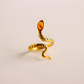 Gold snake ring on a beige background