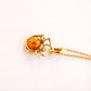 Gold amber necklace with a heart-shaped amber pendant on a white background
