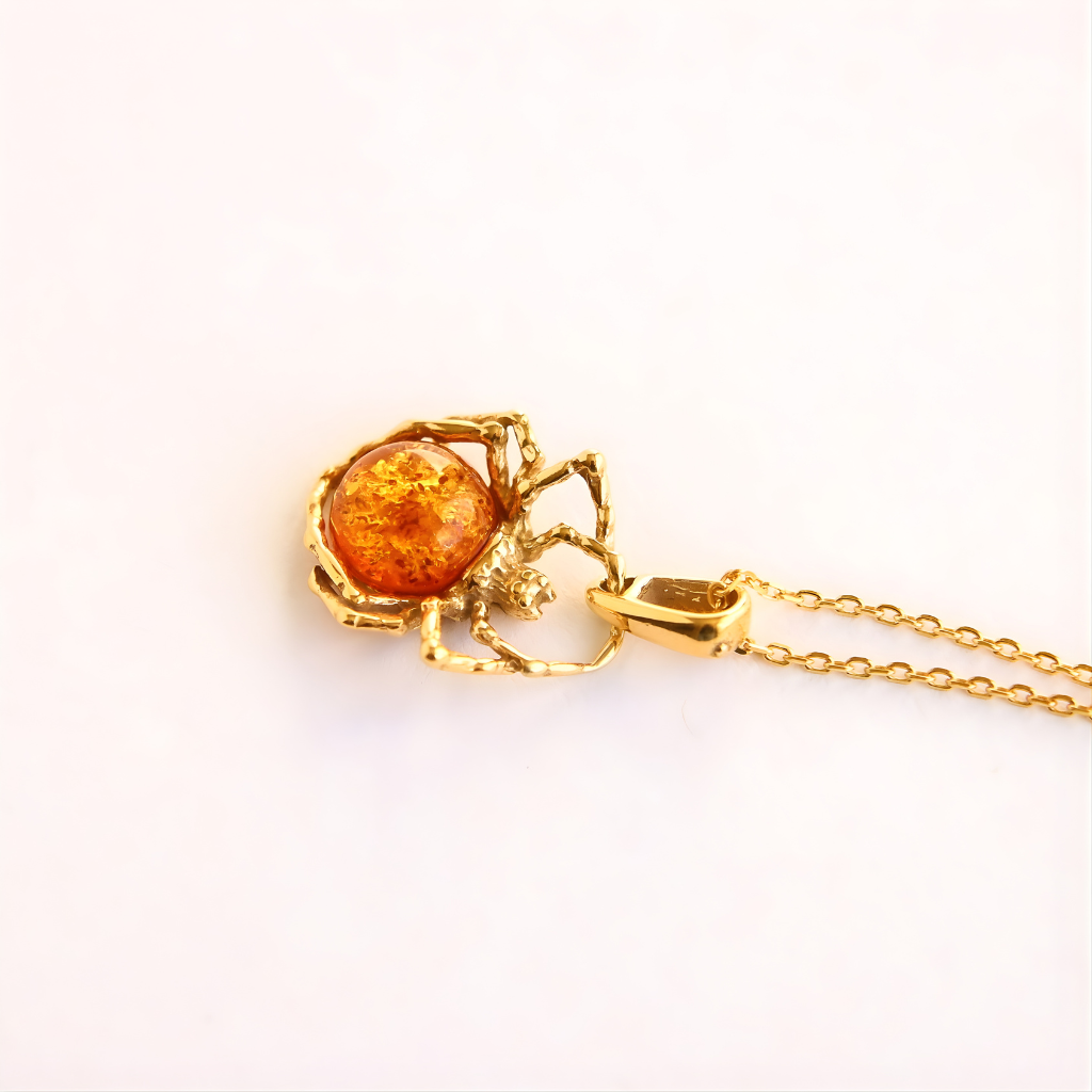 Gold amber necklace with a heart-shaped amber pendant on a white background