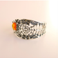 Silver amber bracelet with a central cognac amber gemstone on a light pink background