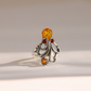 A silver amber octopus ring featuring a large oval amber stone at the top, with three smaller round amber stones set into ornate silver scrollwork, photographed on a light beige background.
