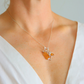 amber Necklace with a pendant featuring orange and silver design on a person wearing a white top.