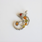 Silver amber pendant with colored stones on a white background